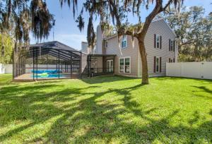 una casa con piscina y un árbol en un patio en Tampa Bay Pool Home with Heated Pool en Brandon