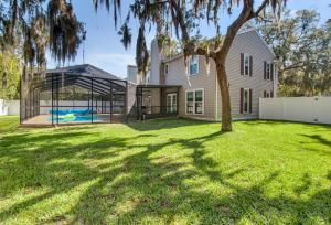 a house with a pool and a tree in a yard at Tampa Bay Pool Home with Heated Pool in Brandon