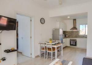 uma cozinha com uma mesa e um relógio na parede em Apartamento Deluxe para Parejas en Punta Cana em Punta Cana