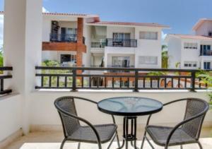 um pátio com 2 cadeiras e uma mesa na varanda em Apartamento Deluxe para Parejas Playa Bavaro Punta Cana em Punta Cana