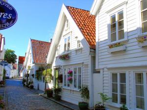 a row of white houses on a cobblestone street at Bnb Central Apartment 5 Downtown Stavanger Stavanger in Stavanger