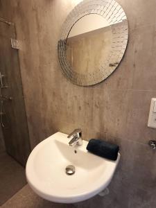 une salle de bain avec un lavabo et un miroir dans l'établissement Central Trio Suites by Stavanger BnB Nr 5, à Stavanger