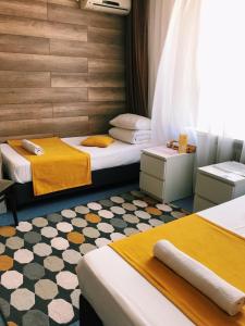 a room with two beds with yellow and white at Italmas Hotel in Izhevsk