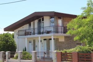 a house with a balcony on top of it at Fenyves Villa in Balatonfenyves