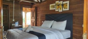 um quarto com uma cama num quarto de madeira em Rinjani Hill Hotel em Sembalun Lawang