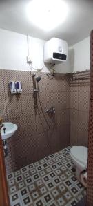 uma casa de banho com um chuveiro, um WC e um lavatório. em Rinjani Hill Hotel em Sembalun Lawang