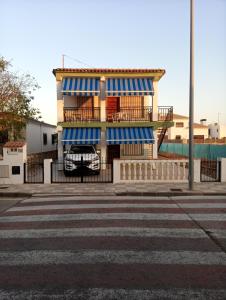 un edificio con strisce blu e bianche su una strada di Apartamentos playa de bellreguard,gandia,oliva,denia,benidorm a Bellreguart