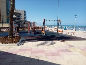 a playground on the beach next to the ocean at Apartamentos playa de Bellreguard in Bellreguart