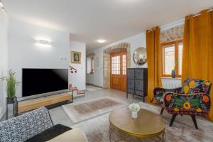 a living room with a tv and a couch and a table at Casa Jagoda in Višnjan