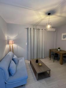 - un salon avec un canapé bleu et une table dans l'établissement Marion Apartments, à Kourouta