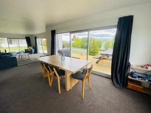 Una sala de estar con una mesa de madera y una gran ventana. en Tekapo Tussock, en Lake Tekapo