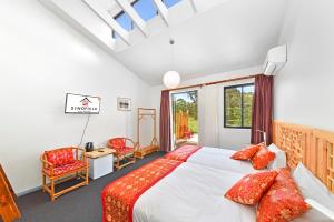 a bedroom with a bed with red pillows at Sinofield Edu-Retreat in Leura