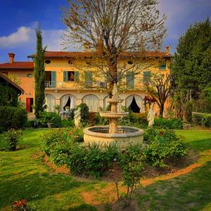 a large building with a fountain in the middle of a yard at Cascina CORTEPRIMAVERA, B&B del Baliot in Passirano