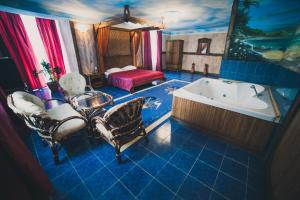 baño azul con bañera, cama y bañera en Vyshegrad Castle Hotel, en Vyshgorod