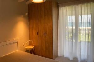 a bedroom with a window with a white curtain at Amazing beach house in Chorefto