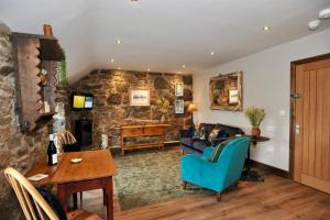a living room with a blue couch and a stone wall at Beach View in Benllech