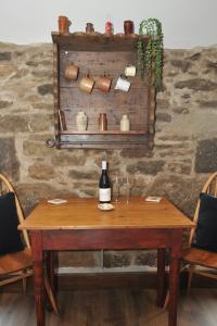 a wooden table with a bottle of wine sitting on it at Beach View in Benllech