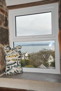 a pillow sitting in front of a window at Beach View in Benllech