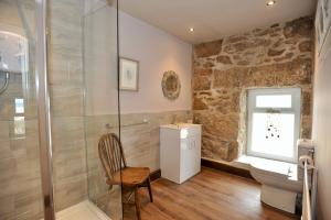 a bathroom with a shower and a toilet and a sink at Beach View in Benllech
