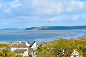 a view of a beach with a house and the ocean at Beach View in Benllech