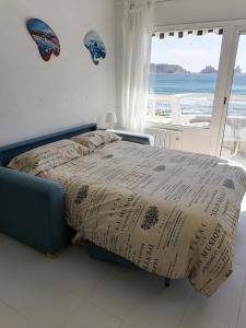 un letto in una camera da letto con vista sull'oceano di L´Estartit, estudio en primera linea de mar. a L'Estartit