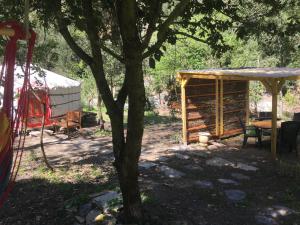 una tienda y un árbol en un patio en Moulin de la Buade, en Termes