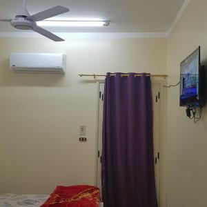 ハルガダにあるSweet Home 5- No Egyptianの天井ファンとカーテンが備わる客室です。