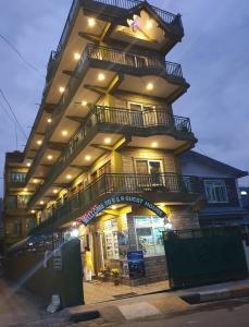 a tall yellow building with balconies on top of it at R&R Guest House in Pokhara