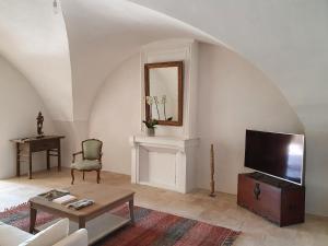 sala de estar con TV y mesa en Les Canisses, magnifique appartement avec terrasse au cœur d'Uzès, en Uzès