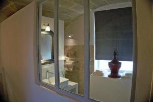 baño con espejo y lavabo en Les Canisses, magnifique appartement avec terrasse au cœur d'Uzès, en Uzès