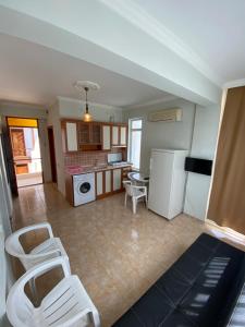 a kitchen with white chairs and a white refrigerator at Erol Apart in Kemer