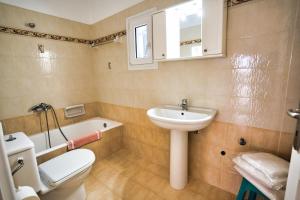 a bathroom with a sink and a toilet and a tub at Sunset 7.59 in Mikonos +48 photos