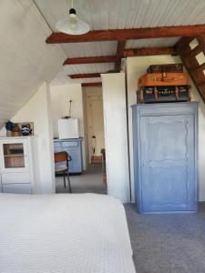 a bedroom with a blue cabinet with luggage on top at Tankefuld Living's Horsefarm in Svendborg