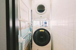 una lavatrice in un bagno con specchio di Blue Spring Villa - Vacation STAY 11143 a Kado