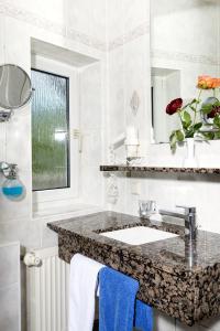 W łazience znajduje się umywalka i lustro. w obiekcie Hotel Adler w mieście Waiblingen