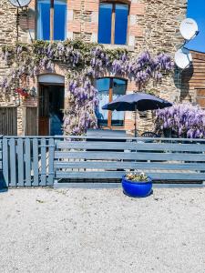 a bench in front of a garden filled with flowers at Maison De Vacances A Brambuan in Josselin