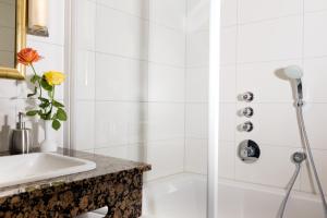 a white bathroom with a shower and a sink at Hotel Adler in Waiblingen