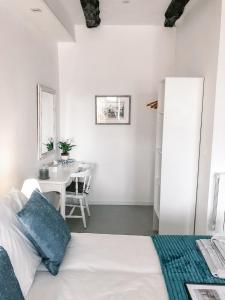 a bedroom with a white bed and white walls at Maison De Vacances A Brambuan in Josselin