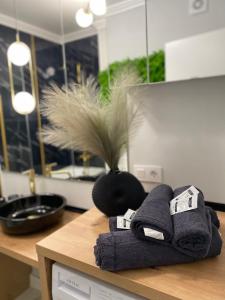 a counter with towels on a table with a vase at Marble Apartments 2 in Oradea