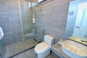 a bathroom with a toilet and a shower and a sink at Lin's Forest in Hengchun South Gate