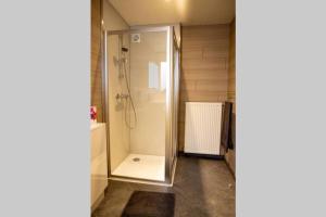 een badkamer met een douche en een glazen deur bij Au Comilfo in Malmedy