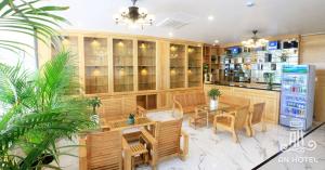 a restaurant with tables and chairs and a refrigerator at An Hotel Phan Thiết in Phan Thiet