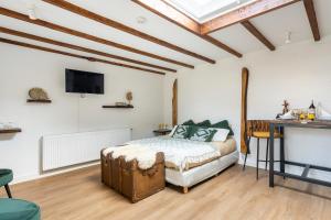 a bedroom with a bed and a tv on the wall at Cottage 44 - Free parking! in Zandvoort