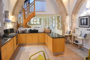a kitchen with wooden cabinets and a staircase in a room at St James House - Converted Church in Hereford