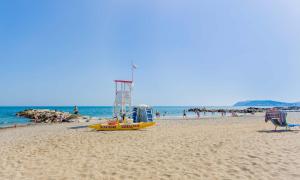 a yellow boat on a beach with a crowd of people at Appartamento vista mare Misano Adriatico in Misano Adriatico