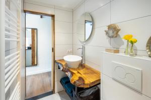 une salle de bain avec un lavabo et un miroir dans l'établissement Cottage 44 - Free parking!, à Zandvoort 41 autres photos