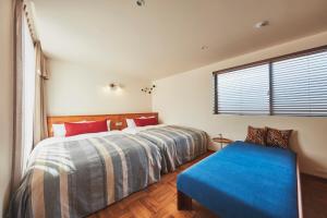 1 dormitorio con cama y banco azul en THE FLOW KAMAKURA, en Kamakura