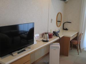 a desk with a large screen television on a table at Hotel Kosaka Gold Palace in Kosaka