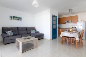 コスタ・テギセにあるApartamento Ideal Costa Teguiseのリビングルーム(ソファ、テーブル付)、キッチンが備わります。