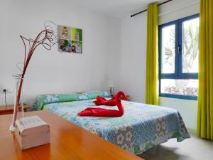 コスタ・テギセにあるApartamento Ideal Costa Teguiseのベッドルーム1室(赤い靴のベッド1台付)